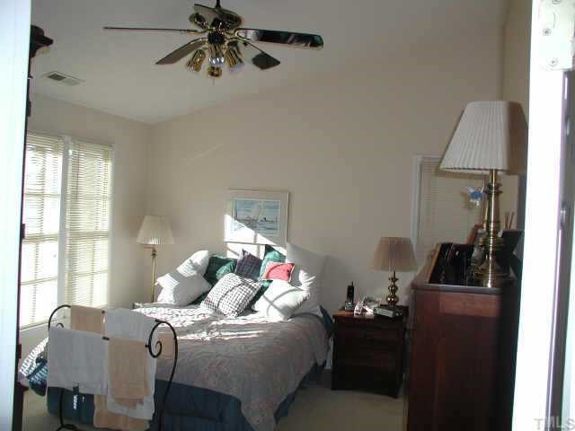 4432 Pike Road Raleigh, NC 27613 - Photo 6 of 10 a bedroom with a bed and wooden floor