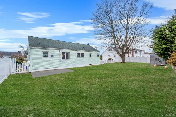 a view of a white house with a big yard