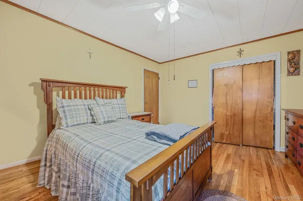 a bedroom with a bed and a wooden floor