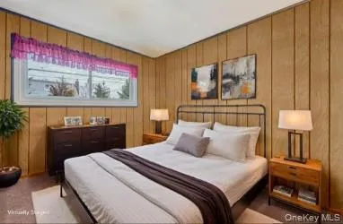 a bedroom with a bed and a painting on the wall