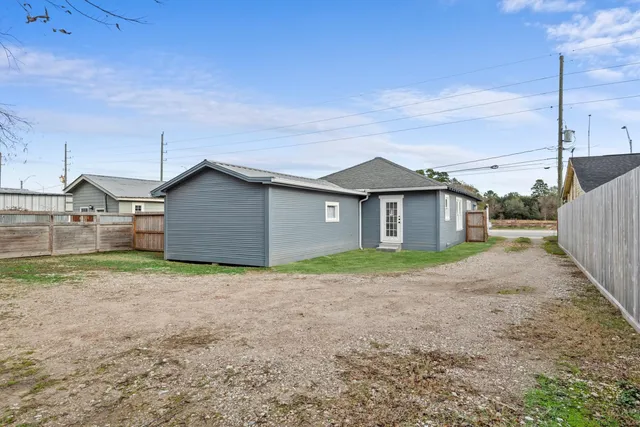 a view of a house with backyard and trees