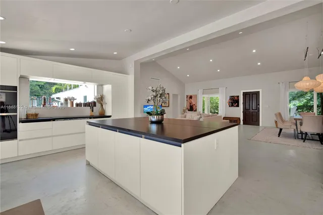 a kitchen with granite countertop a sink and white cabinets