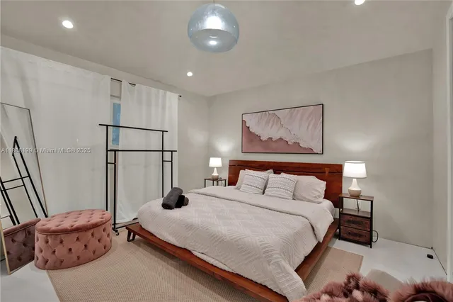 a bedroom with bed and a painting on the wall