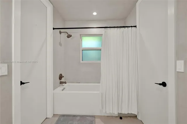 a bathroom with a shower and a bath tub