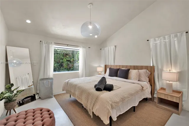 a large bedroom with a bed and wooden floor