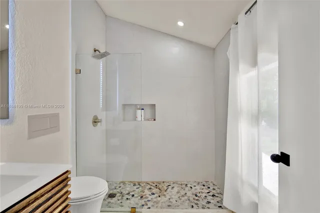 a bathroom with a shower toilet and sink