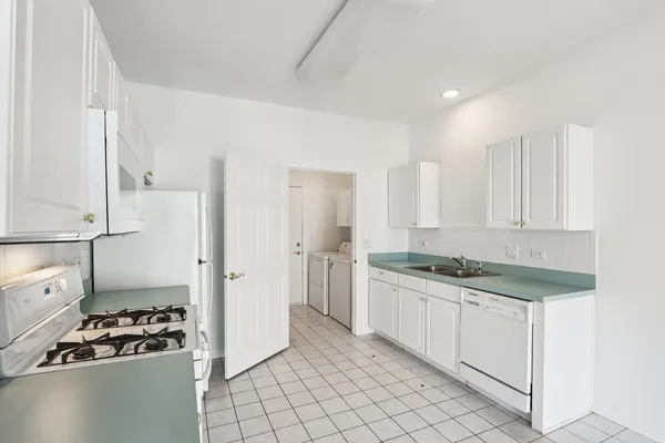 a kitchen with granite countertop a sink stove and cabinets