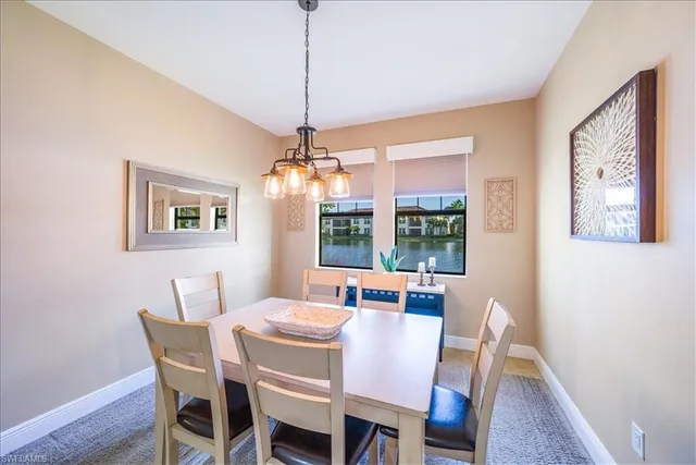 a dining room with furniture a chandelier and window