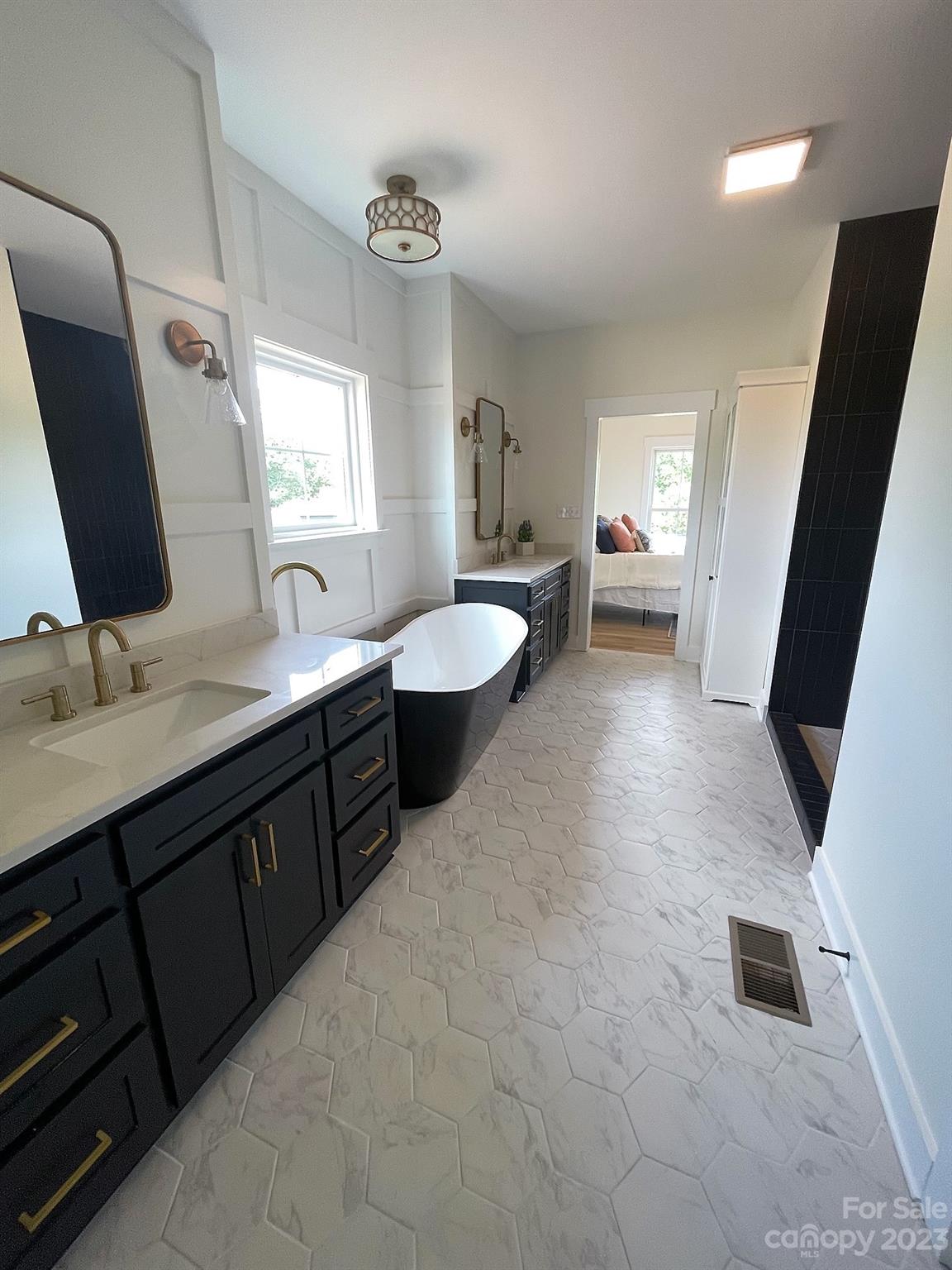 215 Cal Kennedy Road Cleveland, NC 27013 - Photo 32 of 39 a spacious bathroom with a double vanity sink a mirror and a bathtub