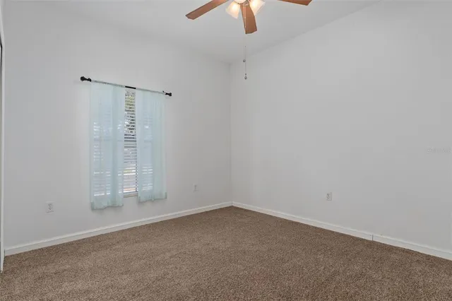 an empty room with chandelier fan