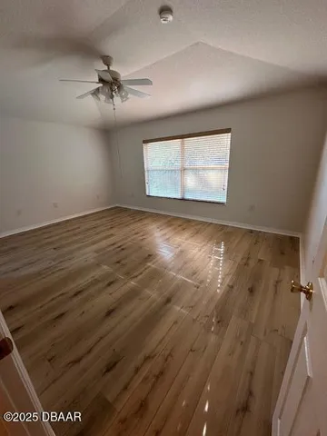 a view of empty room with wooden floor