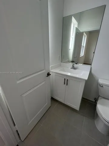a bathroom with a sink a toilet and mirror