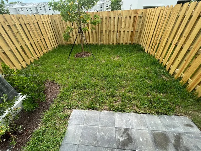 a view of garden with wooden fence