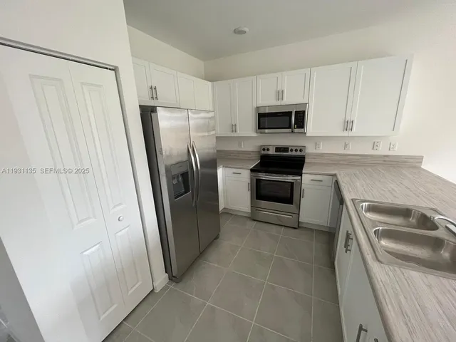 a kitchen with a refrigerator sink and microwave
