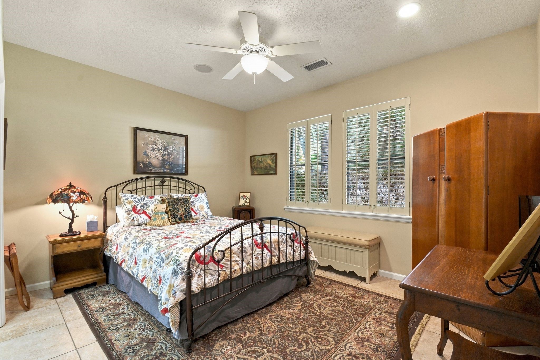 20341 Bay Hill Road Point Blank, TX 77364 - Photo 25 of 50 Secondary bedroom featuring warm lighting, and ample natural light from large windows with shutters.