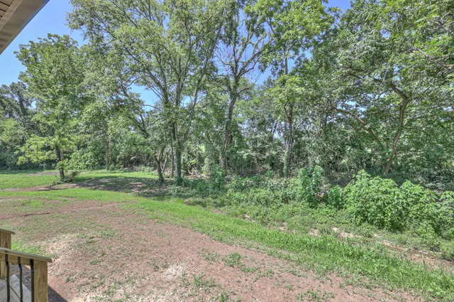 a kitchen with stainless steel appliances a stove top oven a sink dishwasher and a refrigerator with wooden floor