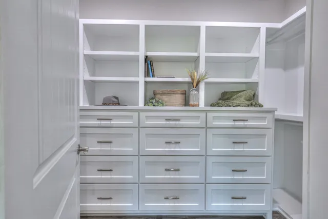 a hallway with a view of bedroom with wooden floor
