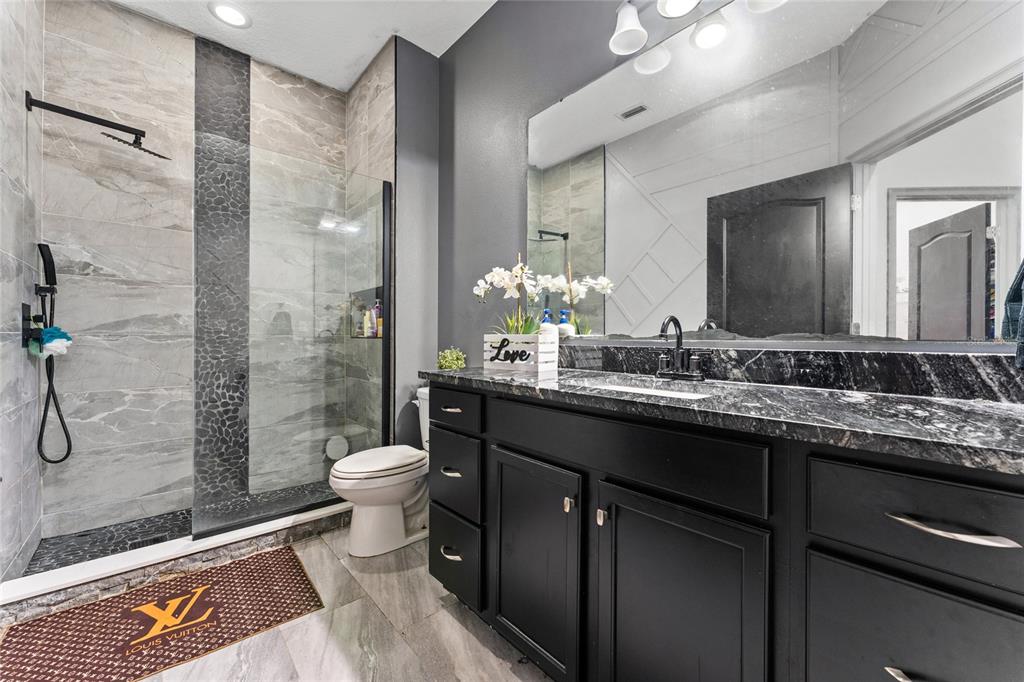 3199 Crispin Circle Harmony, FL 34773 - Photo 17 of 37 a bathroom with a double vanity sink toilet and shower