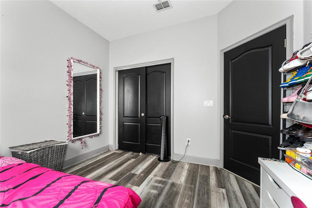 3199 Crispin Circle Harmony, FL 34773 - Photo 19 of 37 a bedroom with two bed and a flat tv screen on dresser