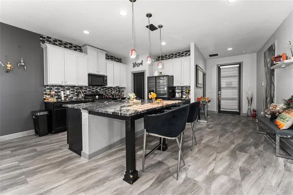 a kitchen with a sink and chairs