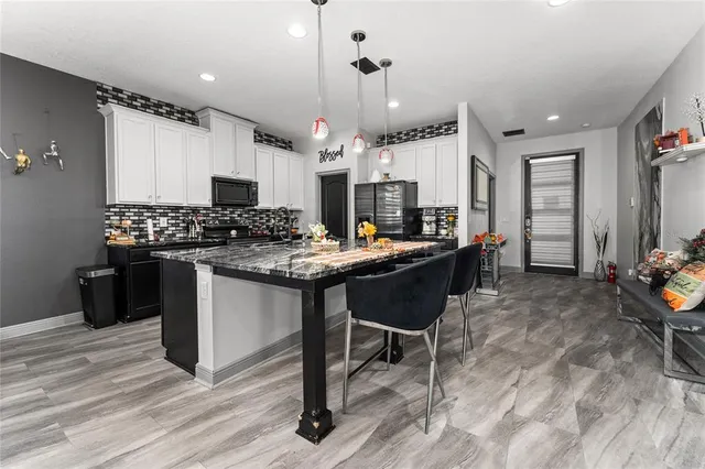 a kitchen with stainless steel appliances granite countertop a refrigerator a stove and a sink