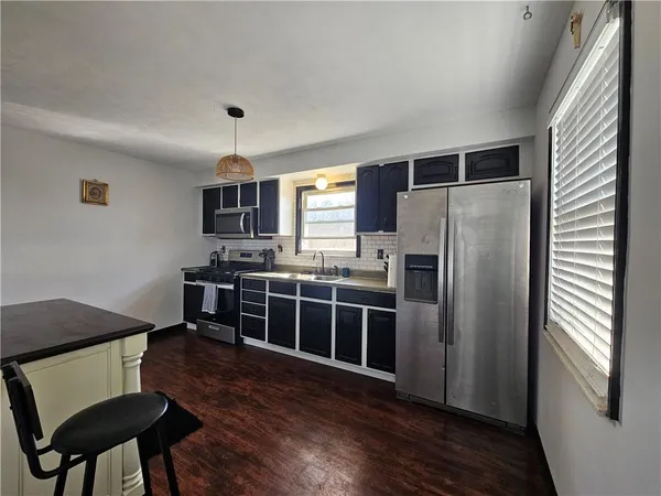 a view of kitchen with sink microwave and refrigerator
