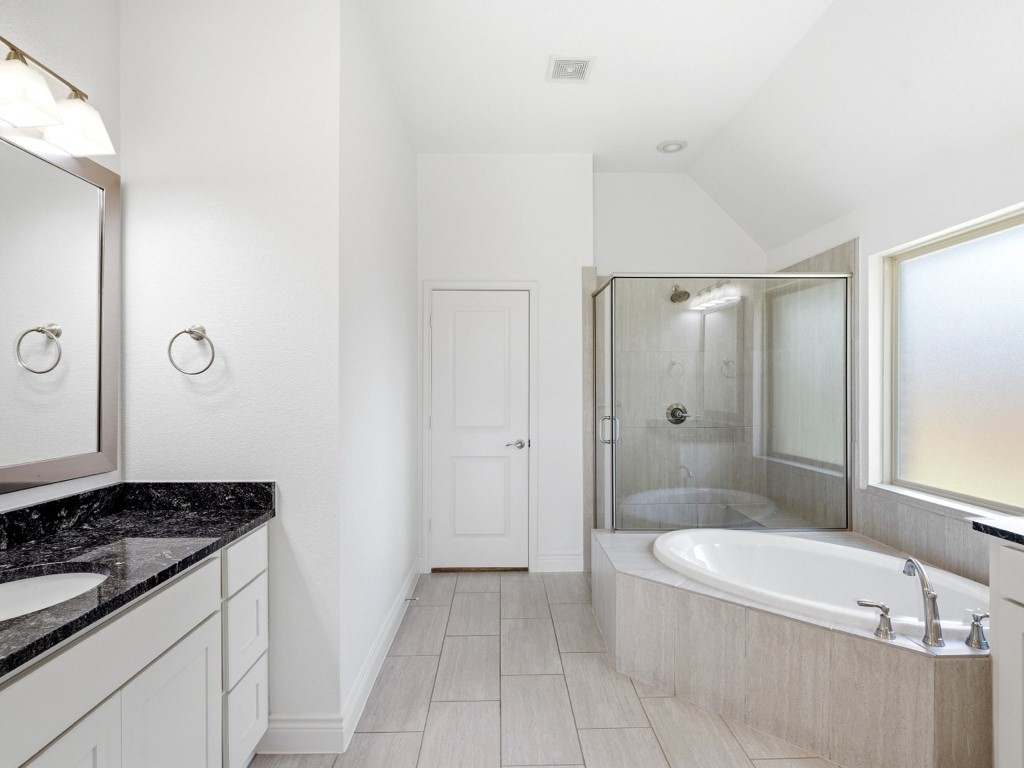 109 Lake Spring Circle Georgetown, TX 78633 - Photo 26 of 38 A well-lit primary bathroom provides a relaxing soak and a refreshing shower.