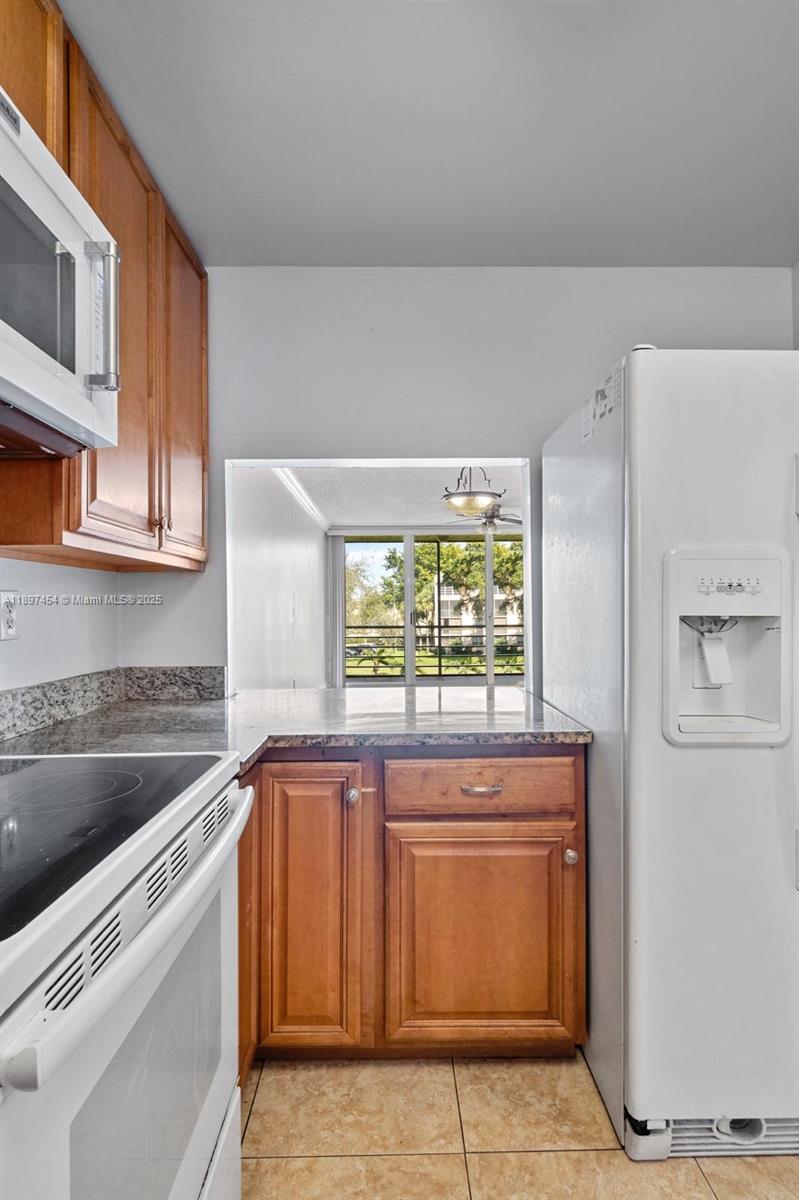9451 Evergreen Place, Unit 303 Davie, FL 33324 - Photo 13 of 23 a kitchen with stainless steel appliances granite countertop a sink and a microwave