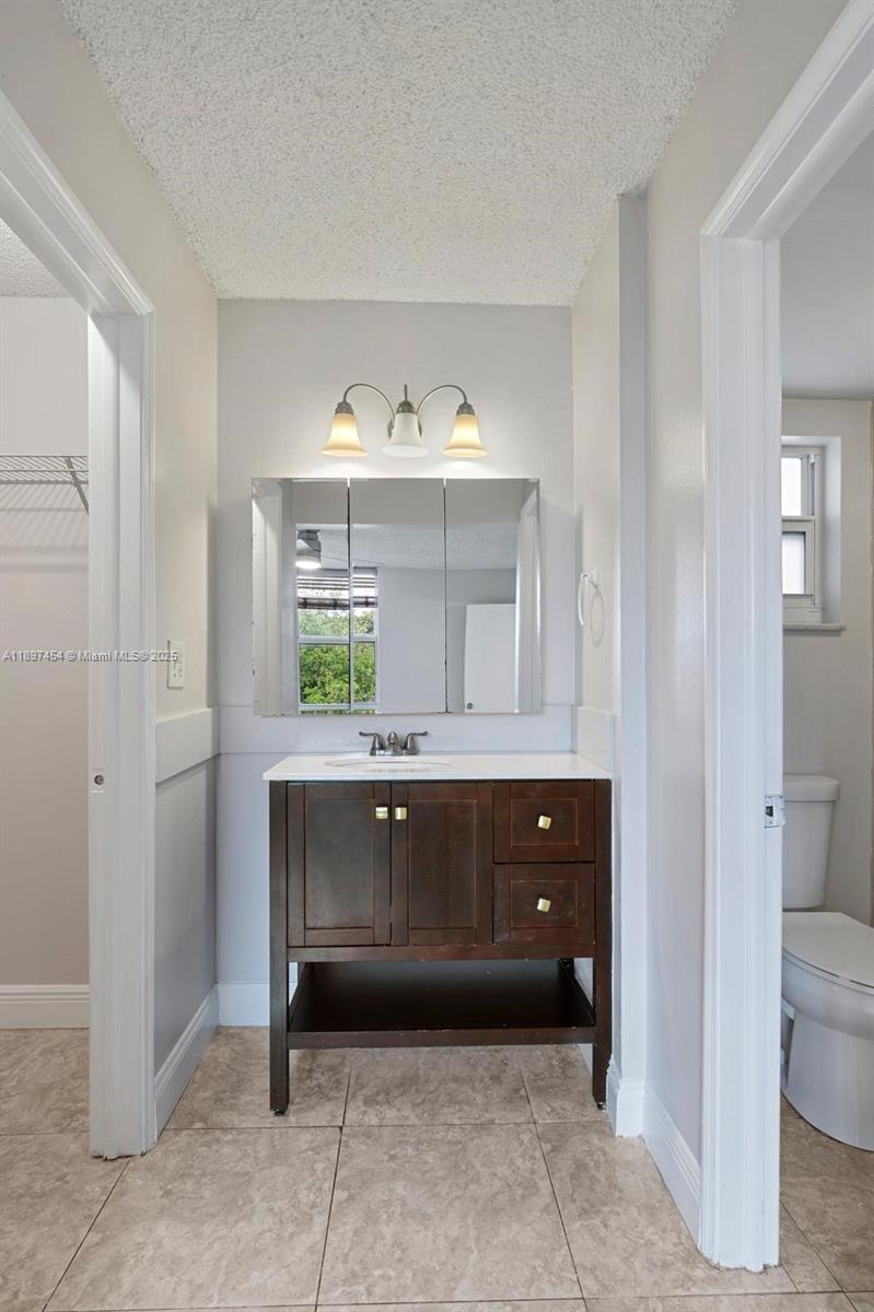 9451 Evergreen Place, Unit 303 Davie, FL 33324 - Photo 18 of 23 a bathroom with a sink and mirror