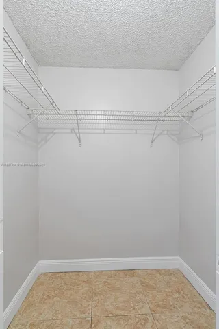 an empty room with closet and a chandelier fan
