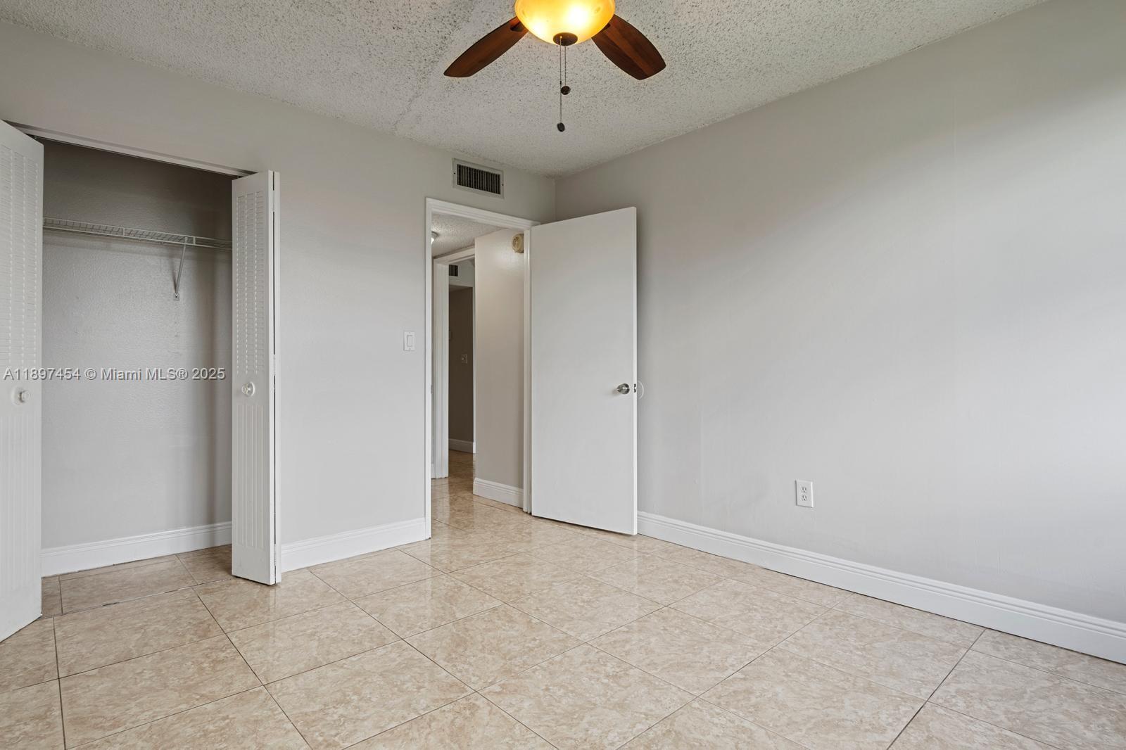 9451 Evergreen Place, Unit 303 Davie, FL 33324 - Photo 21 of 23 an empty room with closet and a chandelier fan