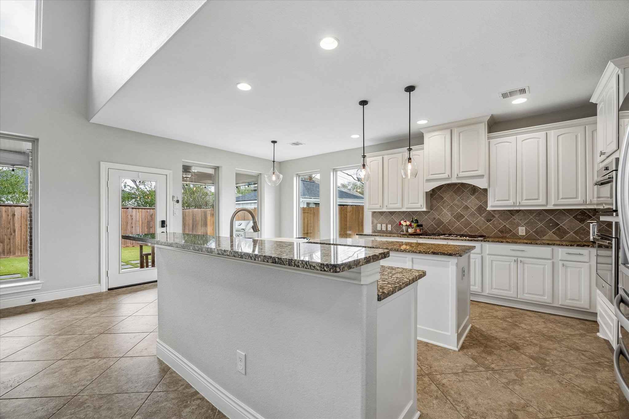 1616 Hewitt Drive Houston, TX 77018 - Photo 10 of 44 Open concept kitchen and breakfast area blend seamlessly together. Stainless steel appliances include a Whirlpool refrigerator, GE ovens and range top, and a Bosch dishwasher replaced in 2020. The bar top island provides additional seating and makes the space ideal for entertaining, allowing the kitchen and main living areas to flow together comfortably.
