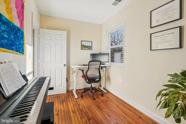 a view of a workspace with furniture and wooden floor
