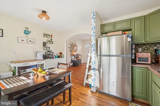 a living room with furniture and a refrigerator