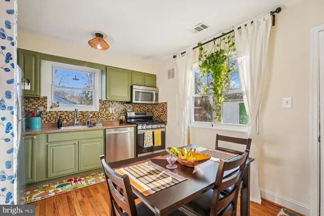 a kitchen with a table chairs and a window