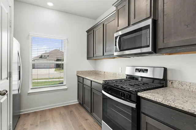 a kitchen with stainless steel appliances granite countertop a stove microwave and sink