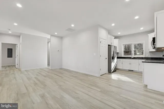 a view of a kitchen with a refrigerator and a stove top oven