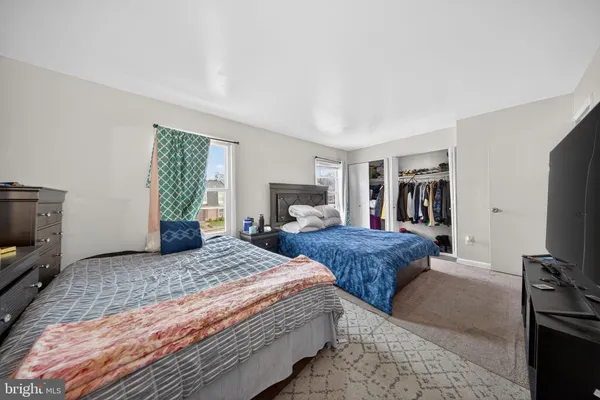 a bedroom with two beds and a flat screen tv