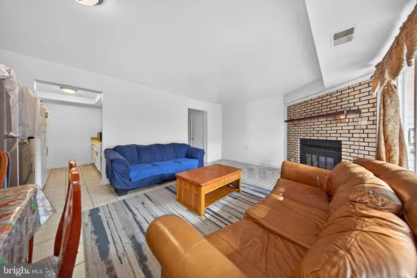 a living room with furniture a fireplace and wooden floor