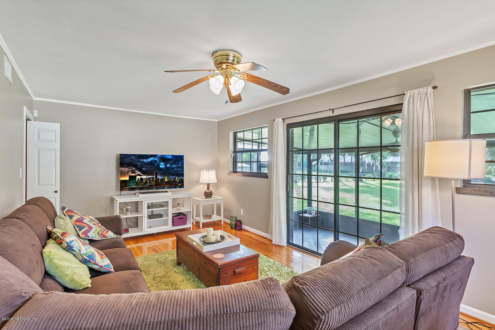 8702 Sanchez Road Jacksonville, FL 32217 - Photo 12 of 34 a living room with furniture a large window and a flat screen tv