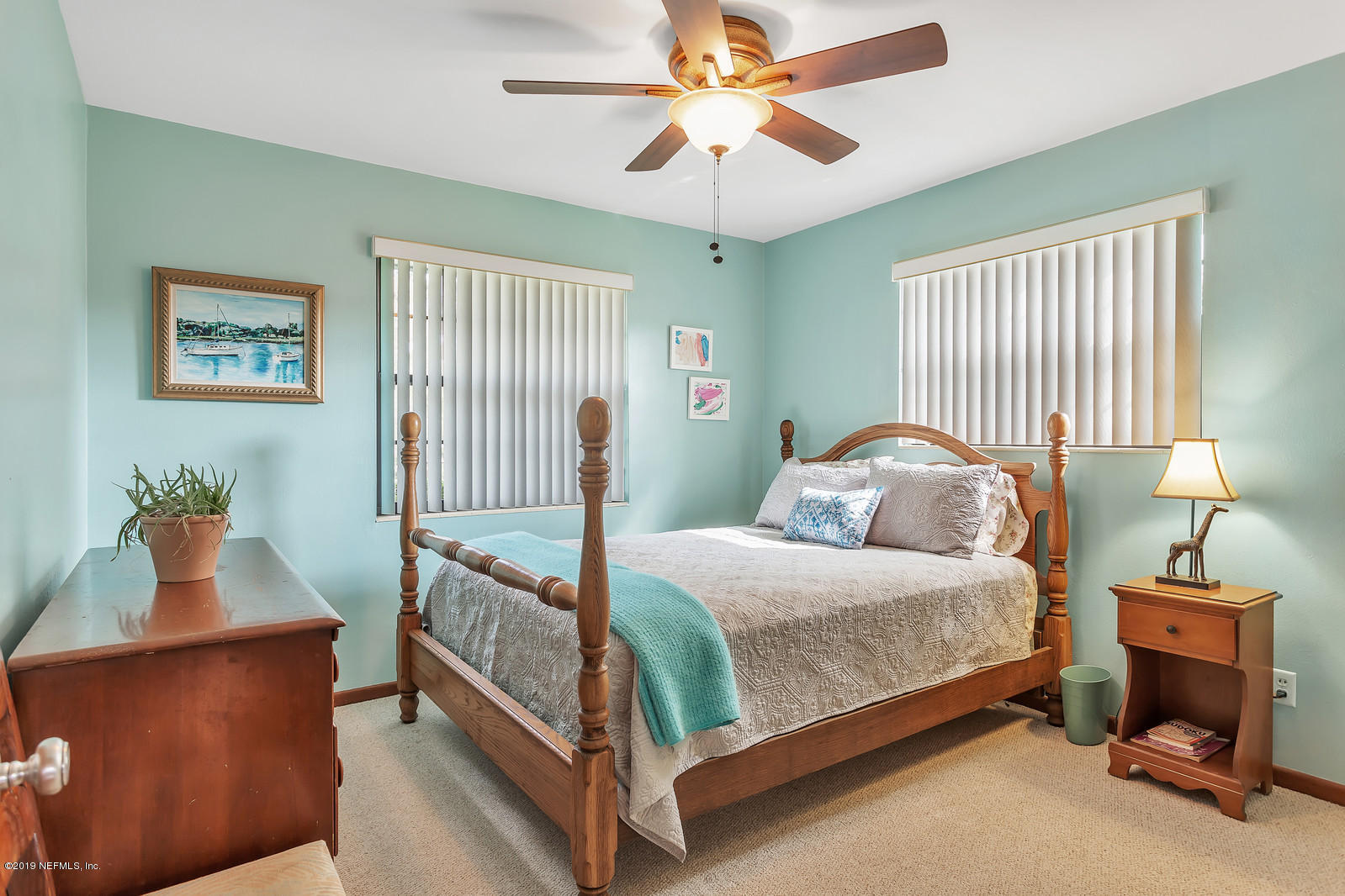 8702 Sanchez Road Jacksonville, FL 32217 - Photo 17 of 34 a bedroom with a bed and a chandelier