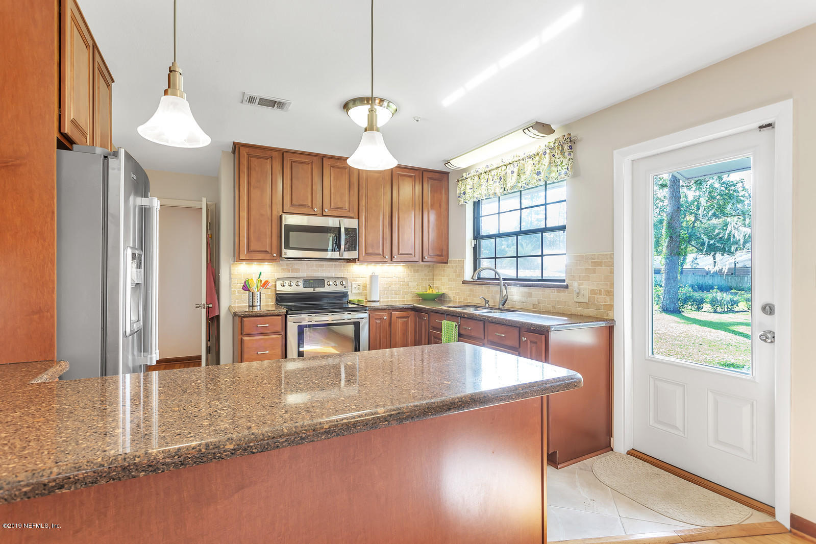 8702 Sanchez Road Jacksonville, FL 32217 - Photo 8 of 34 a kitchen with stainless steel appliances granite countertop a sink a stove and a refrigerator