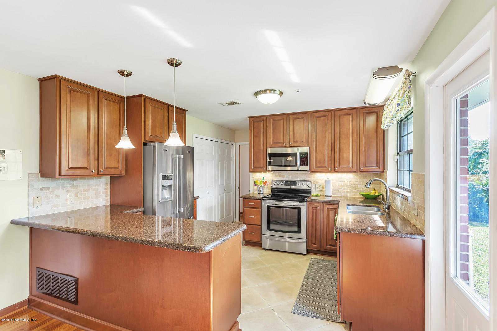 8702 Sanchez Road Jacksonville, FL 32217 - Photo 9 of 34 a kitchen with stainless steel appliances granite countertop a stove refrigerator sink and microwave