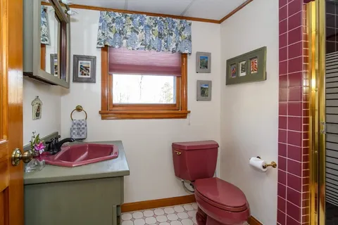a bathroom with a toilet sink and mirror