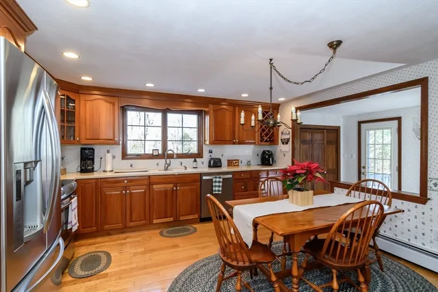 a kitchen with stainless steel appliances granite countertop a kitchen island hardwood floor sink stove dining table and chairs