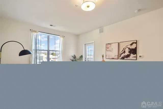 a kitchen with stainless steel appliances granite countertop a stove a sink a refrigerator white cabinets and wooden floor