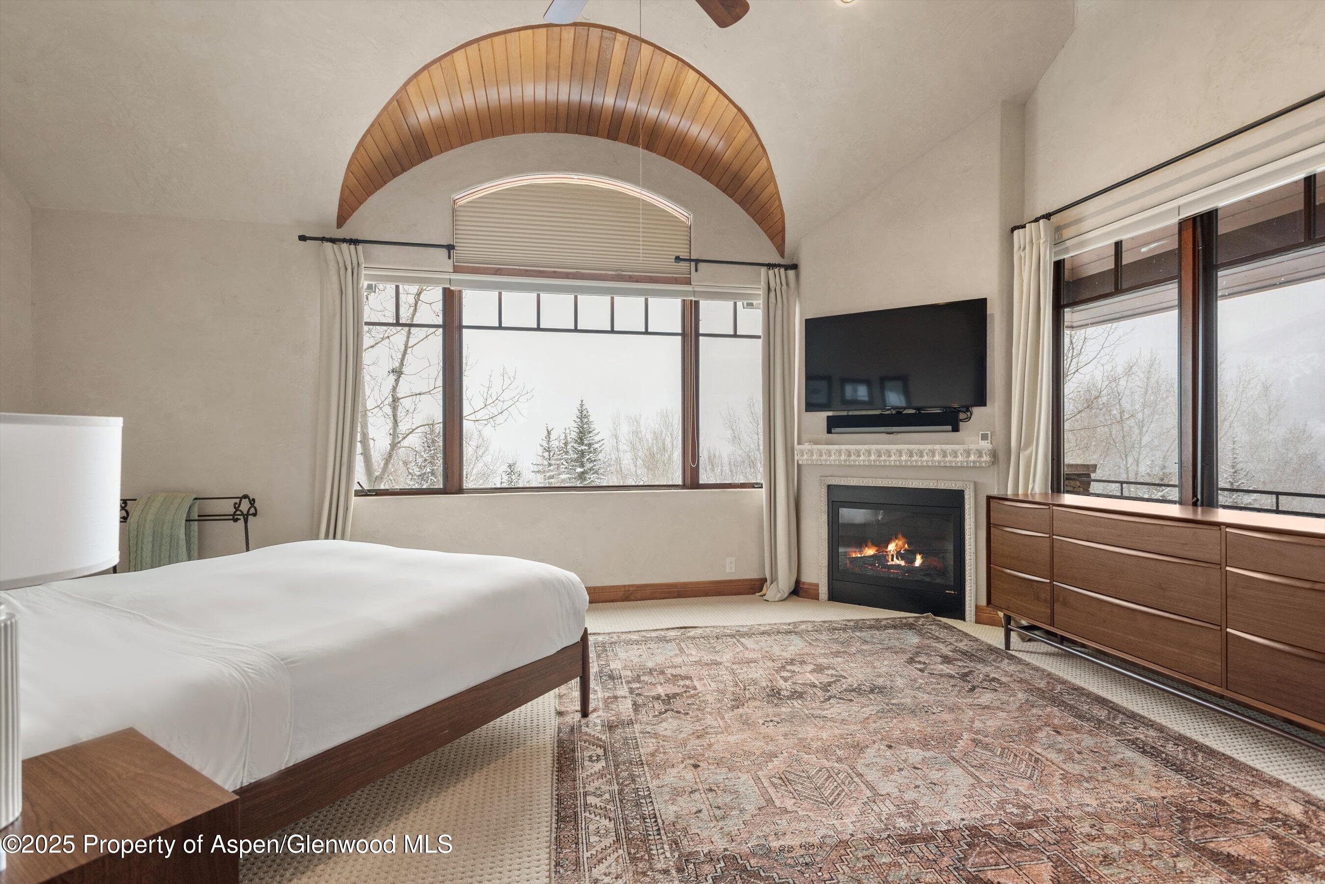 121 Oak Ridge Road Snowmass Village, CO 81615 - Photo 16 of 28 a spacious bedroom with a bed and a fireplace
