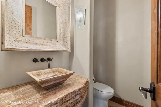a bathroom with a toilet sink and mirror