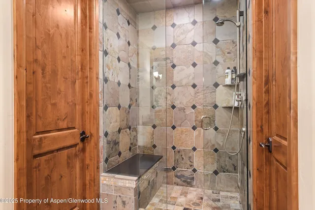 a bathroom with a granite countertop shower and a sink
