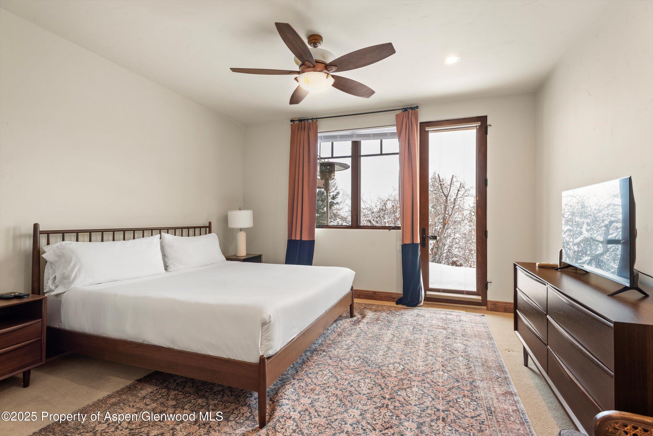 121 Oak Ridge Road Snowmass Village, CO 81615 - Photo 24 of 28 a bedroom with a large bed and a flat tv screen on dresser